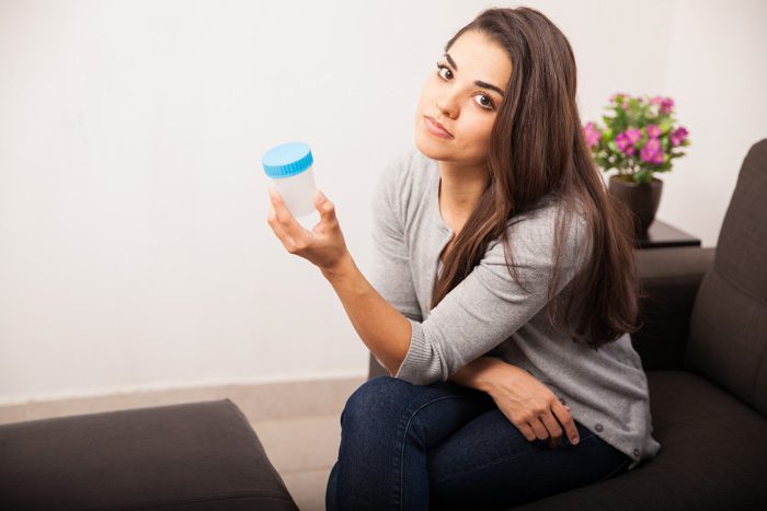 urine drug testing and teens - girl holding specimen cup - twin lakes recovery center