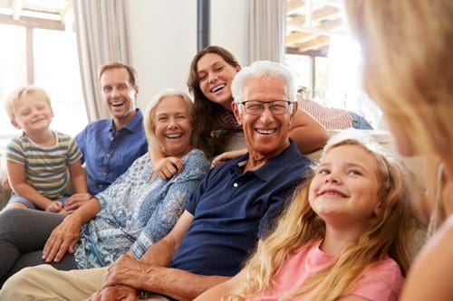 multiple generations of a family all together on the couch visiting - your family