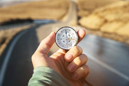 person standing on road looking at compass - after relapse