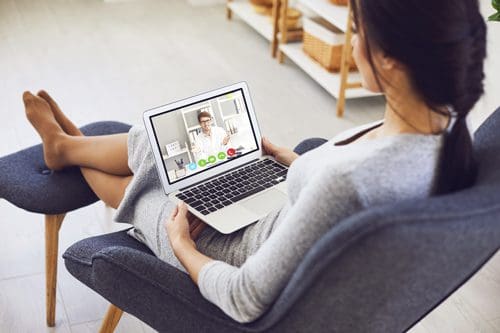 woman using small laptop for video conference - online