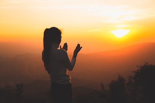 woman on hill or mountain during sunset - spirituality