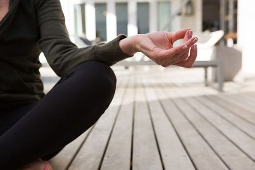 off-center closeup of woman meditating in the lotus position - spirituality resources