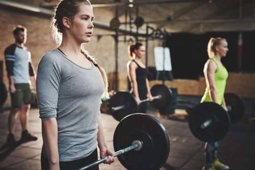 woman and others lifting weights in class - staying fit