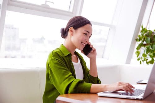 beautiful woman talking on the phone and using her computer - recovery center